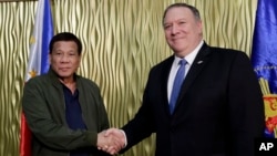 Philippine President Rodrigo Duterte, left, greets U.S. Secretary of State Mike Pompeo at Villamor Air Base in Pasay city southeast of Manila, Philippines, Feb. 28, 2019. Pompeo arrived for talks on the two countries' relations and mutual defense treaty.