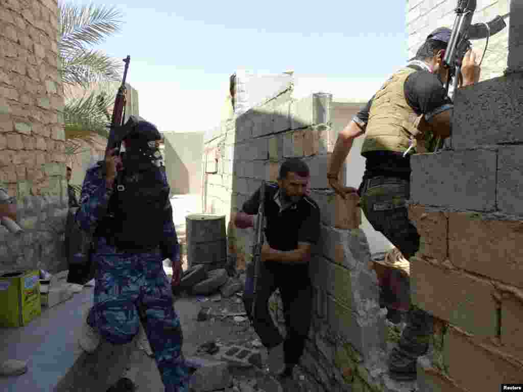 Members of Iraqi security forces and tribal fighters patrol the outskirts of the city looking for Islamic State militants, Ramadi, Sept. 14, 2014.