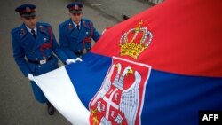 FILE - Serbian soldiers hold their country's flag in Belgrade. 