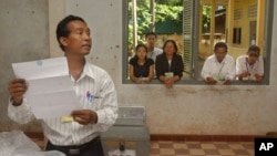 An election worker calls votes off a ballot as election observers look on through a window, (file photo).