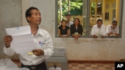 An election worker calls votes off a ballot as election observers look on through a window, (file photo). 