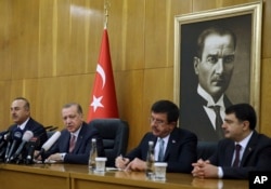 FILE - Turkish President Recep Tayyip Erdogan, second left, flanked by Foreign Minister Mevlut Cavusoglu, left, Economy Minister Nihat Zeybekci, second right, and Istanbul Gov. Vasip Sahin, speaks to reporters in Istanbul, Jan. 5, 2018. Erdogan slammed the conviction in New York of a Turkish banker accused of helping Iran evade sanctions, saying the U.S. justice system poses a danger for the world.