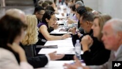 People have their resumes reviewed at a job fair. Some experts say there is a "skills gap" between jobseekers and jobs. Some researchers however say evidence of a skills gap is weak.