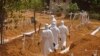 FILE - Health workers walk inside a new graveyard as they move bury people suspected of dying from the Ebola virus on the outskirts of Monrovia, Liberia, March 11, 2015. 