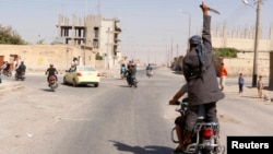 Un miembro de Estado Islámico levanta un puñal en una la provincia siria de Raqqah.