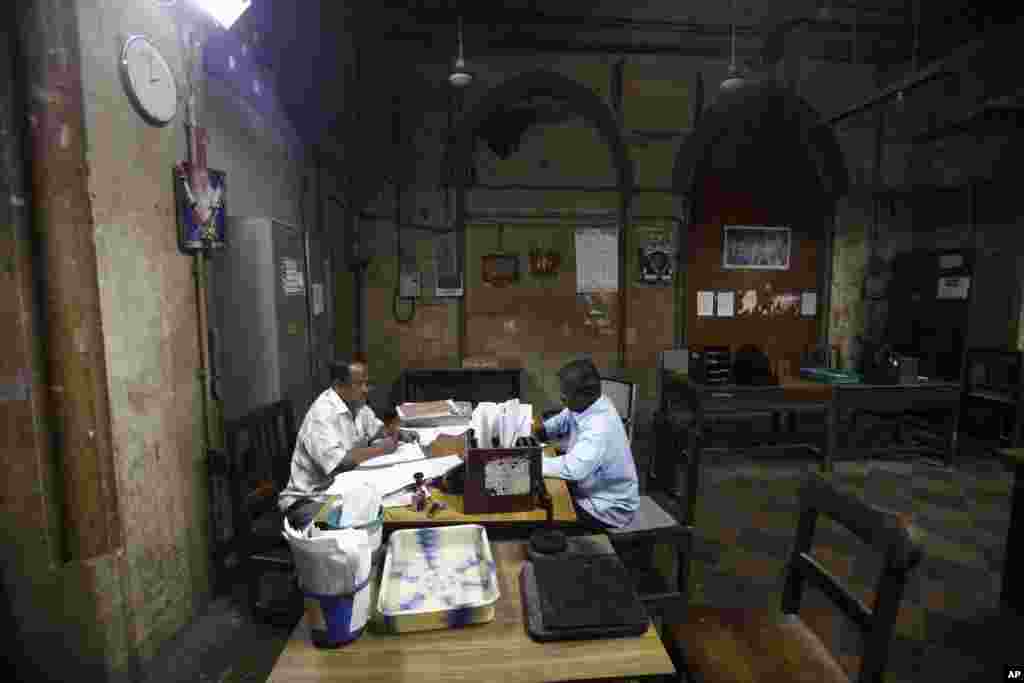 Indian telegraph employees process telegrams on the last day of the service at the central telegraph office in Mumbai, July 14, 2013.