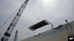 Installation work is carried out on a roof at unit 3 turbine building at the tsunami-crippled Fukushima Daiichi Nuclear Power Station in Fukushima prefecture in Japan, July 18, 2011