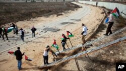 FILE - Palestinian activists use ladders to cross over the Israeli separation barrier to pray on Friday at the al-Aqsa Mosque in the Old City of Jerusalem. 