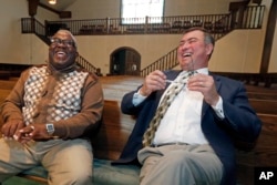 Bishop Clarence Green of Hopewell Missionary Baptist Church (left) and Pastor James Nichols of the First Baptist Church of Greenville laugh together inside the chapel that First Baptist offered as a temporary home for the members of Hopewell, Nov. 22, 2016.