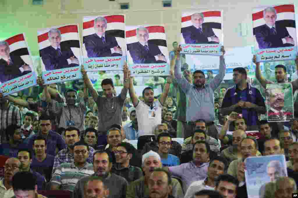 Supporters of presidential candidate Hamdeen Sabahi raise posters of him during his campaign in Mahalla, 125 kilometers north of Cairo, May 5, 2014.