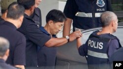 North Korean Ri Jong Chol (second from right) is escorted by police to a car at Sepang district police station in Sepang, Malaysia, March 3, 2017. 