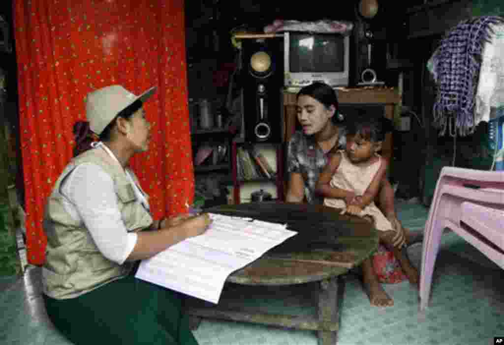 A Myanmar census enumerator asks questions to a housewife while collecting information in Dala township Sunday, March 30, 2014, in Yangon, Myanmar. Enumerators fanned out across Myanmar on Sunday for a census that has been widely criticized for stoking r