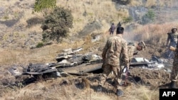 Binh sĩ Pakistan bên chiếc chiến đấu cơ bị bắn hạ.