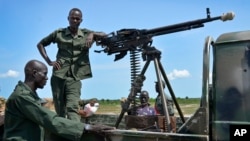 FILE - Government soldiers stand guard by their vehicle on the front lines in the town of Kuek, northern Upper Nile state, South Sudan.