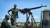 Les soldats du gouvernement montent la garde près de leur véhicule sur les lignes de front dans la ville de Kuek, dans le nord de l'état du Haut-Nil, au Sud-Soudan.