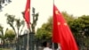 资料照：中越外长在河内举行会谈前，一名男子在越南政府办公机构前竖起的越南国旗旁升起中国国旗。（2017年11月2日）