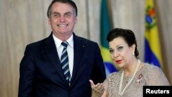 Brazil's President Jair Bolsonaro, left, stands with Venezuela's ambassador to Brazil Maria Teresa Belandria during the credentials presentation ceremony of several new diplomats, at the Planalto Palace in Brasilia, Brazil, June 4, 2019. 