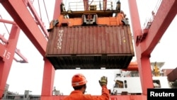 资料：中国江苏连云港码头一雇员正在指挥吊车从货轮上卸下集装箱
