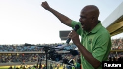 Le Président de l'Association des mineurs et syndicats des travailleurs dans le domaine de la construction (AMCU), Joseph Mathunjwa, parle aux travailleurs en grève au stadium Royal Bafokeng, à Rustenburg, 23 juin 2014.