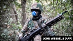 Un membre des Forces armées sénégalaises observe une base rebelle du Mouvement des forces démocratiques de Casamance (MFDC) récemment capturée à Blaze Forest, le 9 février 2021.