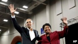 El expresidente Barack Obama y la candidata demócrata para gobernador de Georgia, Stacey Abrams saludan a seguidores durante un mitin de campaña en Morehouse College, Atlanta, el viernes 2 de noviembre de 2018. AP/John Bazemore.