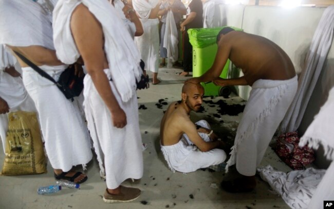 Peregrinos musulmanes hacen fila mientras esperan afeitarse la cabeza de forma gratuita después de arrojar piedras a un pilar que simboliza la lapidación de Satanás, en el primer día de Eid al-Adha, al final de la peregrinación anual del haj. Agosto 11 de 2019. AP foto.