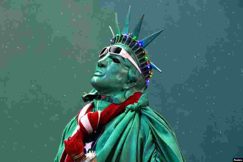 A street performer dressed as the Statue of Liberty stands amongst light snow in Times Square in New York City.&nbsp;