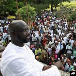 George Weah, a former soccer star and the running mate of presidential candidate Winston Tubman of the Congress for Democratic Change (CDC), stands at the balcony after a news conference at his headquarters in Monrovia, November 5, 2011