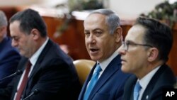 Israeli Prime Minister Benjamin Netanyahu, center, sits next to Cabinet Secretary Tzachi Braverman, right, and Israeli Intelligence and Transportation Minister Israel Katz, at the start of the weekly Cabinet meeting in Jerusalem, Feb. 11, 2018. 