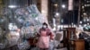 Una mujer, usando mascarilla y una bolsa plástica como protección, traslada bolsas con desechos reciclables en Manhattan, Nueva York, en plena pandemia.