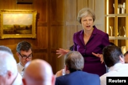 FILE - Britain's Prime Minister Theresa May commences a meeting with her cabinet to discuss the government's Brexit plans at Chequers, the Prime Minister's official country residence, near Aylesbury, Britain, July 6, 2018.