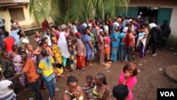 File d'électeurs attendant de voter devant un bureau de vote à Conakry, en Guinée, le 11 octobre 2015. (Photo: C. Stein/VOA)