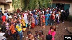 Para pemilih antri di sebuah TPS dalam pilpres di ibukota Guinea, Conakry, Minggu (11/10).