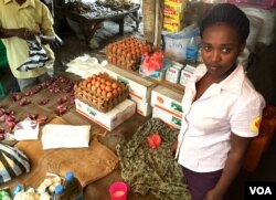 Ruth Kyomukama, a 26-year-old Ugandan, has lived in South Sudan for one year. Here, she is pictured selling commodities from her stall at the Nyakuron market in Juba. December 6, 2016. (Jill Craig / VOA)