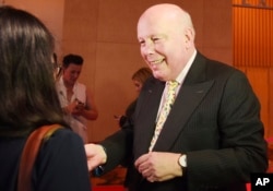 FILE - Julian Fellowes, writer of television series Downtown Abbey greets fans on the red carpet at the launch of an exhibition about the television series at the Marina Bay Sands on June 21, 2017, in Singapore.