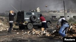 Palestinos lanzan piedras a la policía israelí durante protestas contra el asentamiento judío de Kdumim, en Cisjordania.