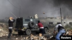 Des manifestants palestiniens jettent des pierres sur un véhicule de police israélienne. (Archives).