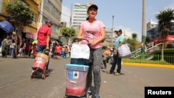 FILE - Days Laguado, a migrant from Venezuela, sells a traditional Venezuelan drink known as 'Tizana' at Gamarra textile cluster in Lima's district of la Victoria, Peru, May 11, 2017.