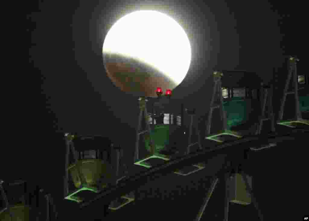 A photographer on a&nbsp; Ferris wheel catches the image of he Earth&#39;s shadow crossing the moon during a total lunar eclipse in Tokyo, Japan, Oct. 8, 2014. 