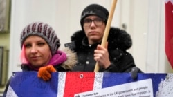 Activists hold a poster to thank the British government for support on a rally at the British embassy in Kyiv, Ukraine, Jan. 21, 2022.