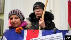 Activists hold a poster to thank the British government for support on a rally at the British embassy in Kyiv, Ukraine, Jan. 21, 2022.