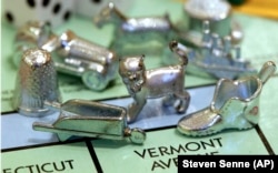 The thimble game piece, left, sits among other Monopoly tokens at Hasbro Inc., headquarters in Pawtucket, R.I. The thimble will no longer be a game piece in Monopoly.