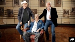 Bobby Bare, left, Jack Clement, center, and Kenny Rogers, right, pose for photographers in the Country Music Hall of Fame in Nashville, Tennessee, April 10, 2013.