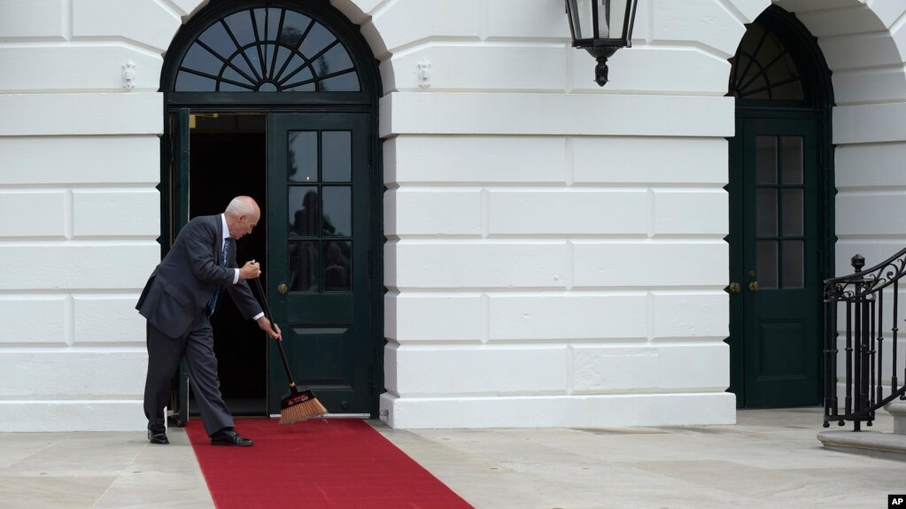 White House event usher Daniel Shanks sweeps the red carpet before President Donald Trump and first lady Melania Trump welcome Panamanian President Juan Carlos Varela and his wife Lorena Castillo to the White House, June 19, 2017.