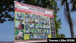 Baliho daftar DPO teroris Poso di depan Mapolres Poso. (VOA/Yoanes Litha)