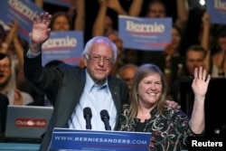 Democratic U.S. presidential candidate Bernie Sanders and his wife, Jane O'Meara Sanders, wave to supporters at a rally in Hollywood in Los Angeles, Oct. 14, 2015.