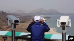 A South Korean tourist uses binocular to look at the Diamond Mountain in North Korea from the Unification Observation post in Goseong, South Korea, April 7, 2017.