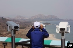 A South Korean tourist uses binocular to look at the Diamond Mountain in North Korea from the Unification Observation post in Goseong, South Korea, April 7, 2017.