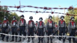 Police stand guard behind barbed wire as they attempt to stop protesters outside Union Election Commission office, Wednesday, Nov. 11, 2020, in Naypyitaw, Myanmar.