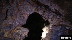 La sombra de un hombre que trabaja como minero se proyecta sobre una roca cuando ingresa a una mina de oro en La Riconada, Los Andes, Perú, el 9 de octubre de 2019.